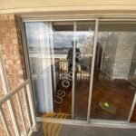 A close-up of a technician installing a new glass sliding door in a Arlington home